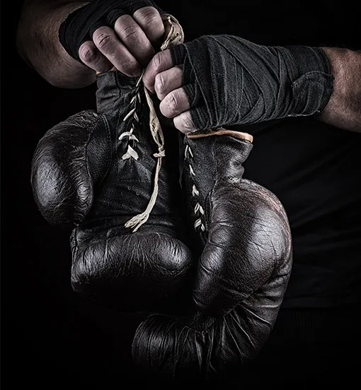 Pair of red boxing gloves hanging ready for training